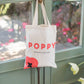 Poppy tote bag hung on door