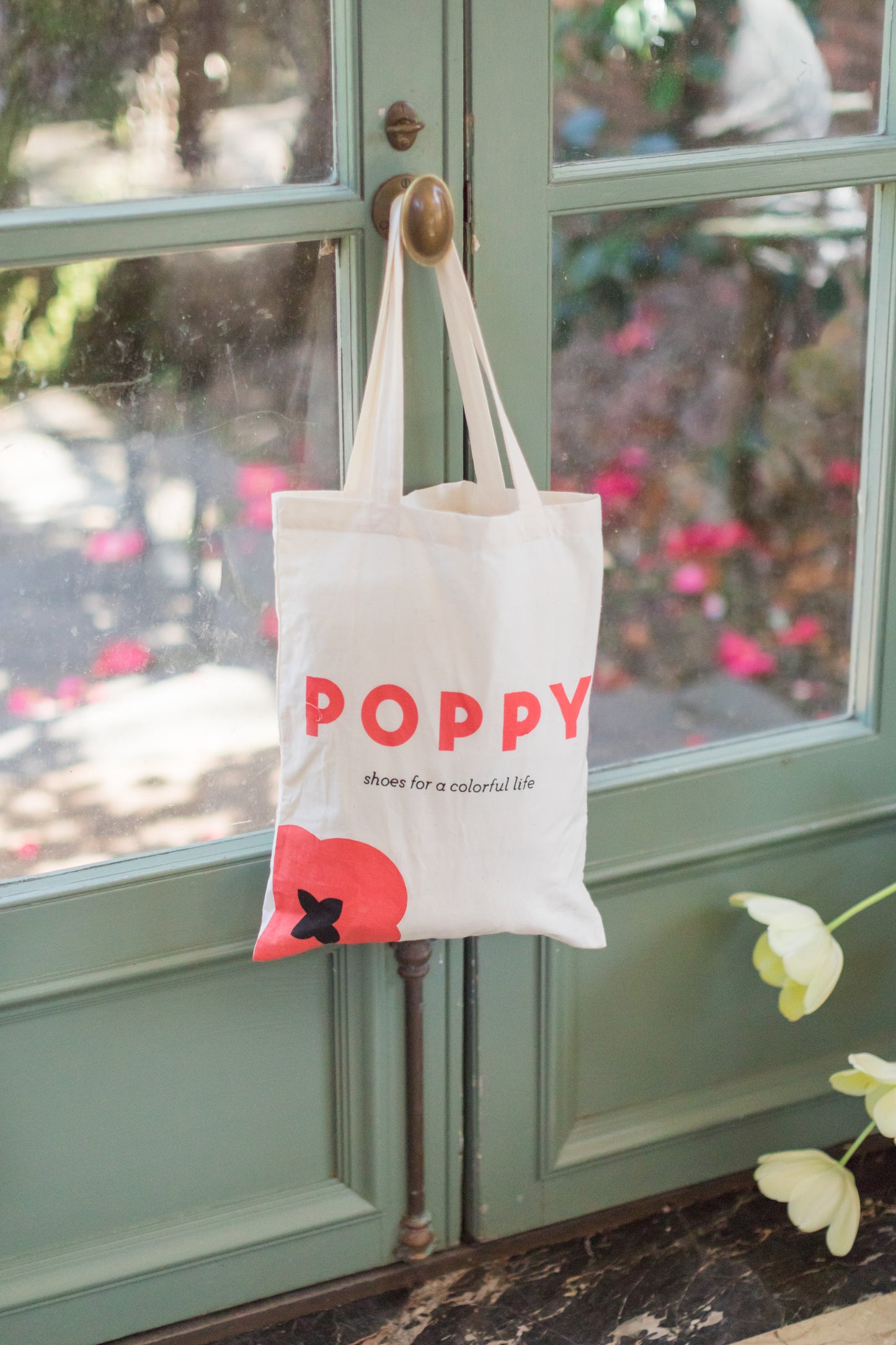 Poppy tote bag hung on door